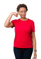 Wall Mural - Beautiful young african american woman wearing glasses over isolated background Pointing with hand finger to face and nose, smiling cheerful