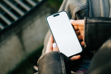 Woman using mobile phone outdoor with a white screen mock up .