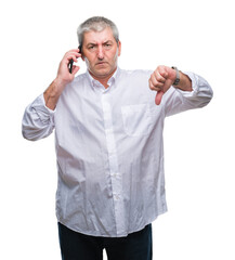 Sticker - Handsome senior man talking on smartphone over isolated background with angry face, negative sign showing dislike with thumbs down, rejection concept