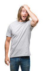 Canvas Print - Young handsome man with long hair over isolated background surprised with hand on head for mistake, remember error. Forgot, bad memory concept.