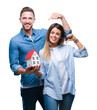 © Krakenimages.com - Young couple in love holding house over isolated background with surprise face pointing finger to himself