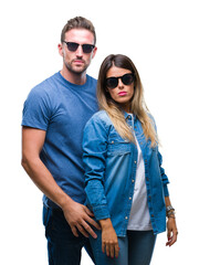 Poster - Young couple in love wearing sunglasses over isolated background with serious expression on face. Simple and natural looking at the camera.