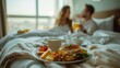 © Onzdemia - Couple enjoying a gourmet breakfast in bed at a luxurious hotel