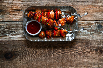 Wall Mural - Chicken skewers kebabs with bell peppers and  onions on wooden board, directly above