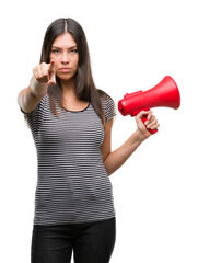 Poster - Young hispanic woman holding megaphone pointing with finger to the camera and to you, hand sign, positive and confident gesture from the front