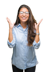 Poster - Young beautiful arab woman wearing glasses over isolated background celebrating mad and crazy for success with arms raised and closed eyes screaming excited. Winner concept