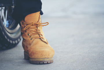 Wall Mural - Men wear construction Boots safety footwear for worker at construction site. Engineer Wear Jeans Brown Boots Worker on Background of Refinery. Engineer safety industry fashion footwear walking outdoor