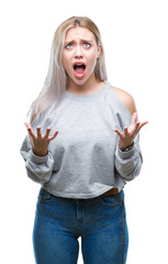 Wall Mural - Young blonde woman over isolated background crazy and mad shouting and yelling with aggressive expression and arms raised. Frustration concept.