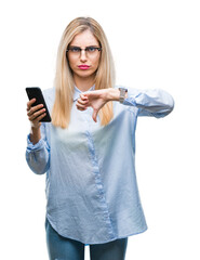 Sticker - Young beautiful blonde business woman using smartphone over isolated background with angry face, negative sign showing dislike with thumbs down, rejection concept