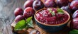 © Ilgun - On a wooden table there is a bowl of plum puree next to fresh fruits ideal for promoting your text with a copy space image