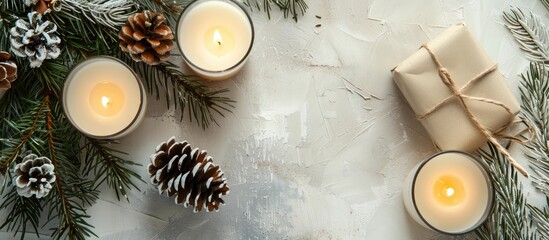 Poster - Top view of Christmas decor with copy space image featuring candles pine cone and gift on a light gray backdrop