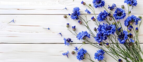 Wall Mural - A desk setup for spring inspiration features a bouquet of cornflowers on a white wooden background with room for additional images