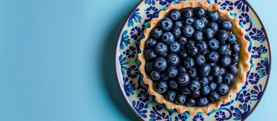 Canvas Print - Overhead shot of a blueberry tart on a colorful plate with plenty of copy space image