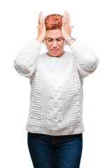 Wall Mural - Atrractive senior caucasian redhead woman wearing winter sweater over isolated background suffering from headache desperate and stressed because pain and migraine. Hands on head.