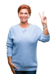 Wall Mural - Atrractive senior caucasian redhead woman over isolated background smiling with happy face winking at the camera doing victory sign. Number two.