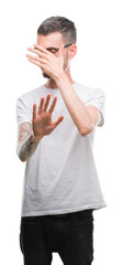 Poster - Young tattooed adult man covering eyes with hands and doing stop gesture with sad and fear expression. Embarrassed and negative concept.