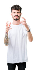 Canvas Print - Young handsome man wearing white t-shirt over isolated background Shouting frustrated with rage, hands trying to strangle, yelling mad