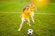 © Louis-Paul Photo - Kids play football on outdoor field at the end of the day