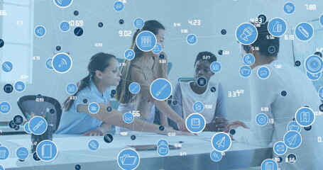 Canvas Print - Image of connected computer icons and numbers over diverse women discussing blueprint in office