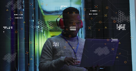 Wall Mural - Image of data processing over african american male engineer using laptop at server room