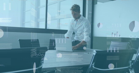 Wall Mural - Image of statistical data processing against thoughtful caucasian man using laptop at office