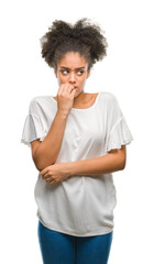 Wall Mural - Young afro american woman over isolated background looking stressed and nervous with hands on mouth biting nails. Anxiety problem.