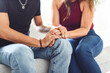 © Louis-Photo - Hand in hand through it all. Shot of an unrecognizable couple holding hands while sitting on a sofa at home.
