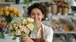 © DARIKA - Smiling florist in an apron arranging a bouquet of flowers in a vibrant shop. Diverse floral designers creating beautiful arrangements and spreading joy with their artistry. Portrait, Realistic