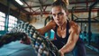 © ORG - Athletic woman doing intense exercise using battle ropes in the gym. Exercise, health care