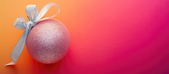 Aufkleber - A decorative Christmas ball with a ribbon bow on a colorful background, presenting a copy space image.