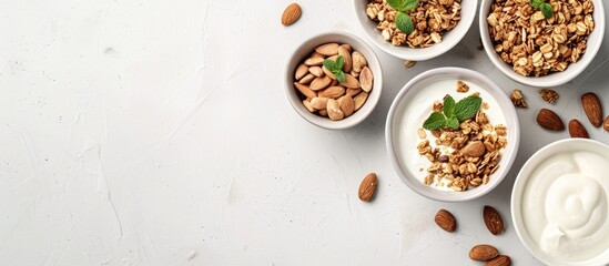 Poster - Top view of yogurt, granola, and almonds in bowls on a white surface with copy space image for an organic breakfast recipe concept.