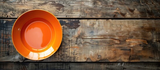 Aufkleber - Aerial perspective of a vacant orange dish on a wooden surface with copy space image.