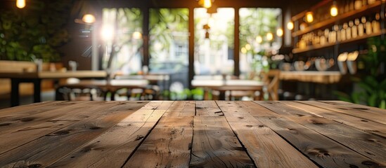 Poster - Empty brown wooden table with selective focus and coffee shop background blurred for a product display montage with copy space image.