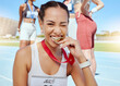 © peopleimages.com - Medal, winner and athlete woman at stadium outdoor with lens flare for competition success, achievement or motivation gen z portrait. Runner, gold award sports girl champion winning a running race