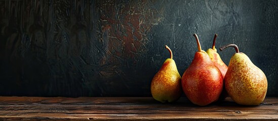 Poster - Ripe pears displayed on a wooden table with a dark background, providing a copy space image.
