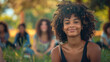 © aditya - an African American woman around a Group of young people sitting on the grass. happy, psychological safety. selective focus, blurred background