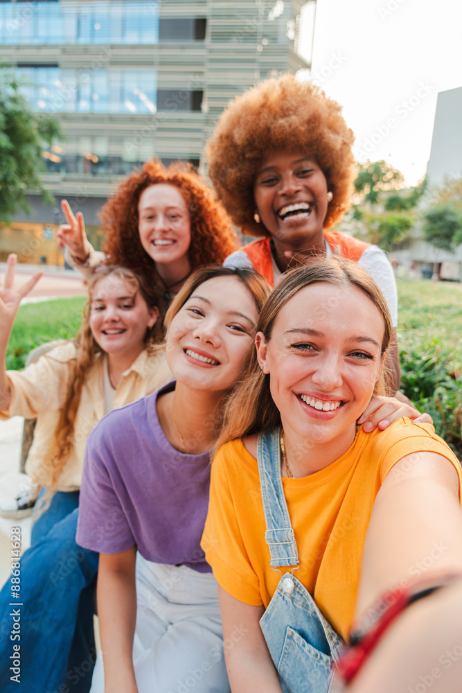 Vertical. Group of only young multiracial women taking a selfie with a ...