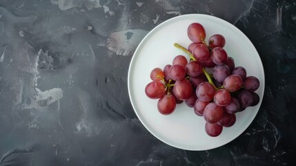 Wall Mural - A plate of grapes is on a dark table