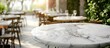 © HN Works - Marble table on a desk with a blurred restaurant background, with copy space image.