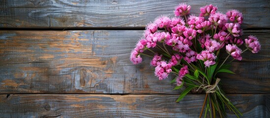 Aufkleber - Bouquet of pink cloves flowers for spring arranged on a rustic wooden surface from above for a flat lay photo with copy space image.