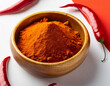 © Amir - Wooden bowl filled with chili powder, text space on white background top view; red papper