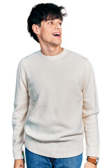 Poster - Handsome hipster young man wearing casual winter sweater looking away to side with smile on face, natural expression. laughing confident.