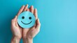 © Andrew - Hand holding blue paper cut happy smile face, Positive thinking, Mental health assessment , World mental health day concept