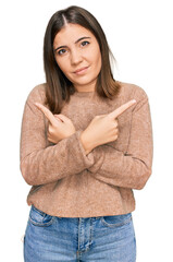 Sticker - Young beautiful woman wearing casual clothes pointing to both sides with fingers, different direction disagree