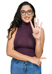 Wall Mural - Brunette young woman wearing casual clothes and glasses showing and pointing up with fingers number four while smiling confident and happy.