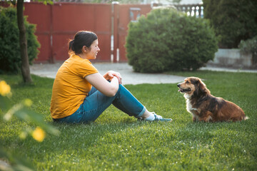 Wall Mural - Woman playing with her dog outdoors