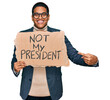 © Krakenimages.com - Young handsome hispanic man holding not my president protest banner smiling happy pointing with hand and finger