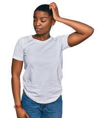 Canvas Print - Young african american woman wearing casual white t shirt confuse and wondering about question. uncertain with doubt, thinking with hand on head. pensive concept.