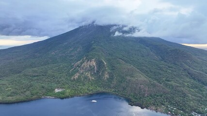 Wall Mural - Clouds gather around the peak of the scenic volcano of Lewotolok on island of Lembata, Indonesia. This beautiful and biodiverse area is part of the famed Ring of Fire and is volcanically active.