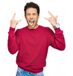 © Krakenimages.com - Young handsome man wearing casual clothes shouting with crazy expression doing rock symbol with hands up. music star. heavy music concept.
